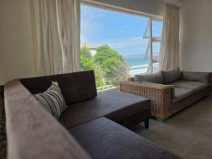 a living room with a couch and a large window at Hartsepunt Seesig in Hartenbos