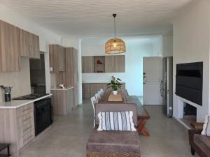 a kitchen with a table and a dining room at Hartsepunt Seesig in Hartenbos