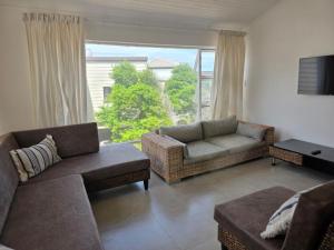 a living room with couches and a large window at Hartsepunt Seesig in Hartenbos