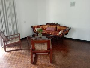 a living room with a couch and a table and chairs at Country Homes Srilanka in Mount Lavinia