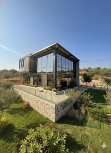 a house with glass windows on top of a yard at AlFahed Farm in Ajloun +29 photos