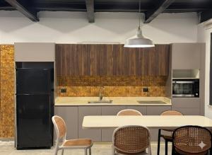 a kitchen with a table and chairs and a black refrigerator at AlFahed Farm in Ajloun