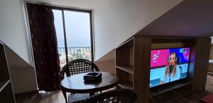 a living room with a small table and a television at Byblos inn, jbeil ,Fidar in Al Fīdār