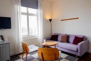 a living room with a purple couch and a table at Sigtuna Stadshotell in Sigtuna