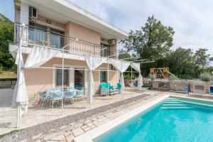 a villa with a swimming pool and a house at Kika's Home in Križišće