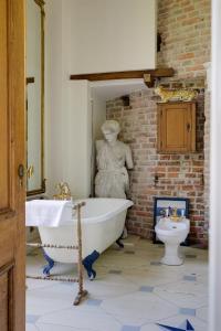 a bathroom with a statue of a woman next to a toilet at Kasteel Sterkenburg in Driebergen