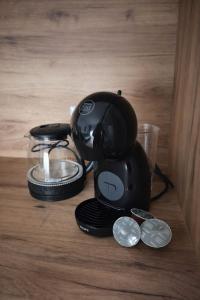 a coffee maker sitting on top of a table with coins at Una Apartmani Musique in Tuzla +2 photos