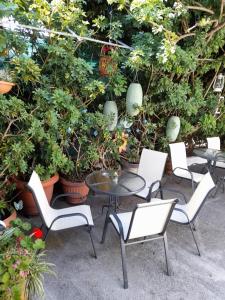 a patio with a table and chairs and plants at Iliada Skiathos rooms in Skiathos