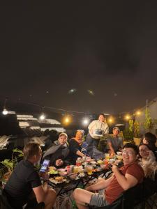 a group of people sitting around a long table with food at 1909 Home Dalat - Open 24h in Ấp Kim Thạch