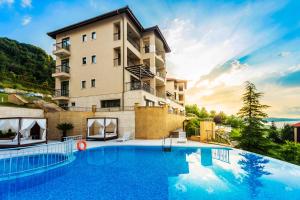 a hotel with a swimming pool in front of a building at Thracian Cliffs Golf & Beach Resort in Kavarna