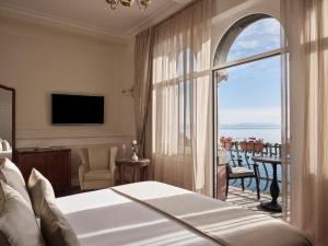 a bedroom with a bed and a view of a balcony at Amadria Park Hotel Milenij in Opatija