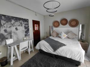 a bedroom with a bed and a desk with two dogs on the wall at Wölfe Krantz Accommodation in Nelspruit