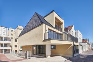an apartment building with a black roof at Michels Dependance des Hotel Misan in Norderney