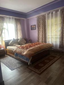 a bedroom with a bed in a room with windows at The Golden Attic in Yangang