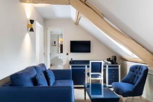 a living room with two blue chairs and a desk at Queen Mary Opera in Paris