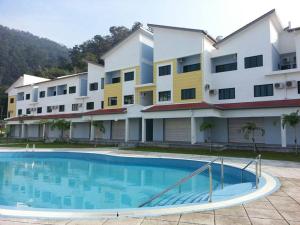 a building with a swimming pool in front of a building at Pangkor Lot 10 Moonlight in Kampong Sungai Udang