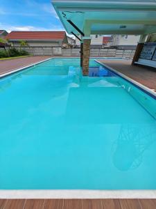 a large swimming pool with blue water at The Shores House-Royal Plams Tres by THE HOUSE in Dauis +29 photos