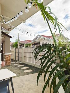 a patio with a fence and a string of lights at The Shores House-Royal Plams Tres by THE HOUSE in Dauis