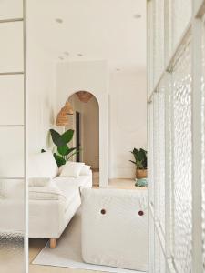 a living room with a white couch and a mirror at The Shores House-Royal Plams Tres by THE HOUSE in Dauis