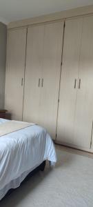 a bedroom with white cabinets and a bed at Caledonia Guest Room in Trichardt