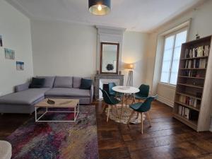 a living room with a couch and a table and chairs at Résidence Austerlitz centre Angouleme in Angoulême