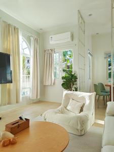 a living room with a white couch and a table at The Shores House-Royal Plams Tres by THE HOUSE in Dauis