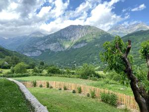 a field with a fence and mountains in the background at Guest House Prebibaj in Curraj i Epërm