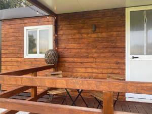 a wooden wall with a bench on a patio at MH Oasi in Stazione di Albinia