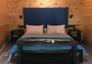 a bed with a blue headboard and a table at The Rising Sun Farm Karjat - Luxury Stays - Couple Friendly in Karjat