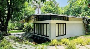 a small house in the middle of a garden at The Rising Sun Farm Karjat - Luxury Stays - Couple Friendly in Karjat