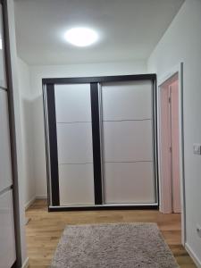 a sliding glass door in a room with a rug at Una Apartmani Musique in Tuzla