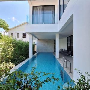 a house with a swimming pool in front of a house at White Cube House in Nathon Bay