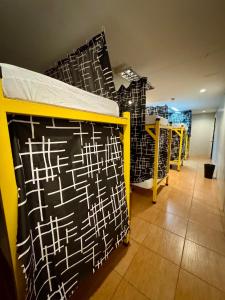 a room with a bed with a black and white wall at Cheese Hostel Manila in Manila