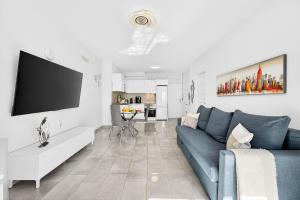 a living room with a blue couch and a tv at Atlantic Penthouse Retreat in Costa Del Silencio +38 photos