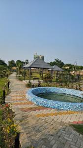 a swimming pool with rocks around it in a park at Balaji Hotel and Resturant in Kolaghat