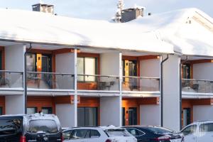a snow covered building with cars parked in front of it at Sivulantie 4 109 by Holiday in Lapland in Äkäslompolo