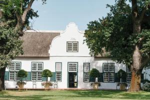 a white house with trees in front of it at Hawksmoor House in Stellenbosch
