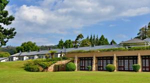 an exterior view of a building with a green lawn at Troutbeck Resort in Nyanga