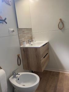 a bathroom with a sink and a toilet and a mirror at MH Oasi in Stazione di Albinia