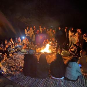 a group of people sitting around a fire at Overnight Luxury Camp in Merzouga
