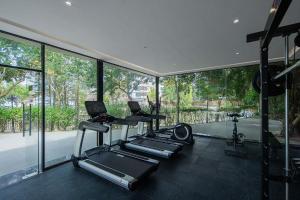 a gym with three treadmills and glass windows at ZSZ Hot Spring Resort in Shajing