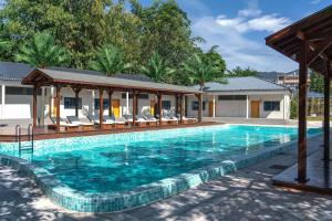 a swimming pool with chairs and a house at ZSZ Hot Spring Resort in Shajing