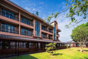 an exterior view of a building with a yard at ZSZ Hot Spring Resort in Shajing