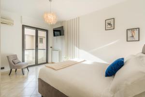 a bedroom with a bed and a chair and a window at Suite Des Etrangers -Parcheggio privato- Private parking in Sanremo