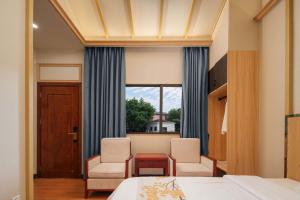 a bedroom with a bed and two chairs and a window at ZSZ Hot Spring Resort in Shajing +69 photos