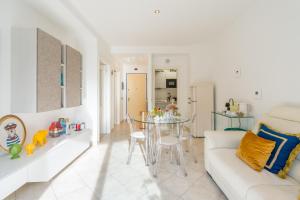 a living room with a white couch and a glass table at Suite Des Etrangers -Parcheggio privato- Private parking in Sanremo
