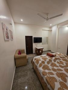 a bedroom with a large bed and a couch at Ghare Stays Udaipur in Udaipur