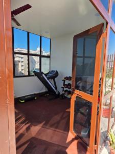 an empty room with a gym with windows and a chair at Ghare Stays Udaipur in Udaipur