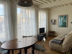 a living room with a table and a couch at LE PETIT MATELOT in Honfleur