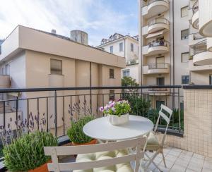 a balcony with a white table and chairs at Suite Des Etrangers -Parcheggio privato- Private parking in Sanremo